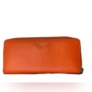 Kate Spade orange wallet. Excellent condition. Almost new. 7 1/2 x 3-3/4 appx.